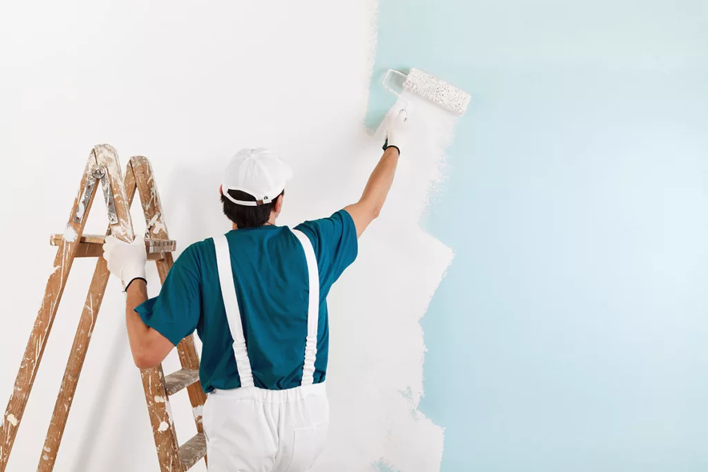 A professional painter paints the interior of a home blue for the New Year.