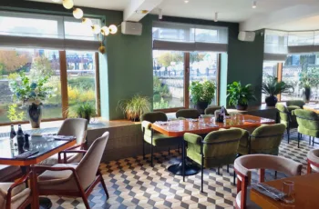 The interior of a restaurant with green paint color and checkered floors, showing the concept of choosing the best paint color for restaurants