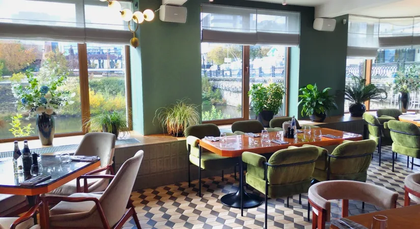 The interior of a restaurant with green paint color and checkered floors, showing the concept of choosing the best paint color for restaurants